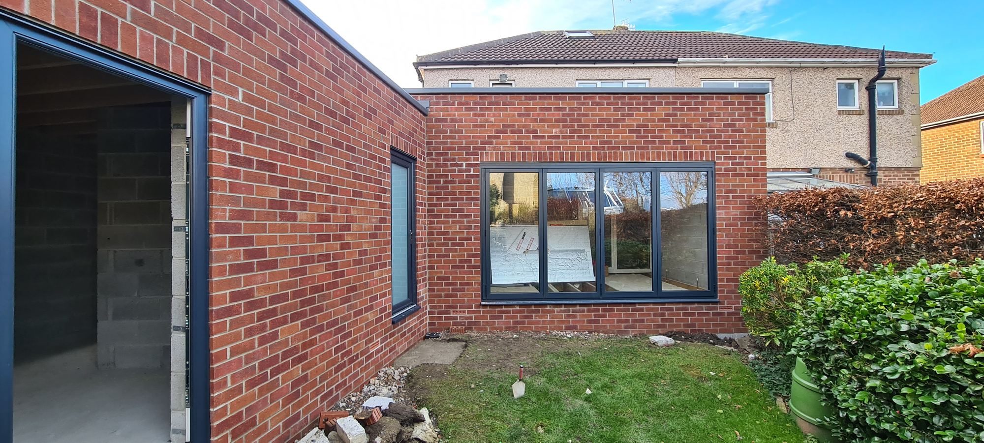 Brick rear extension, garden side, new window in and the garden still to make good