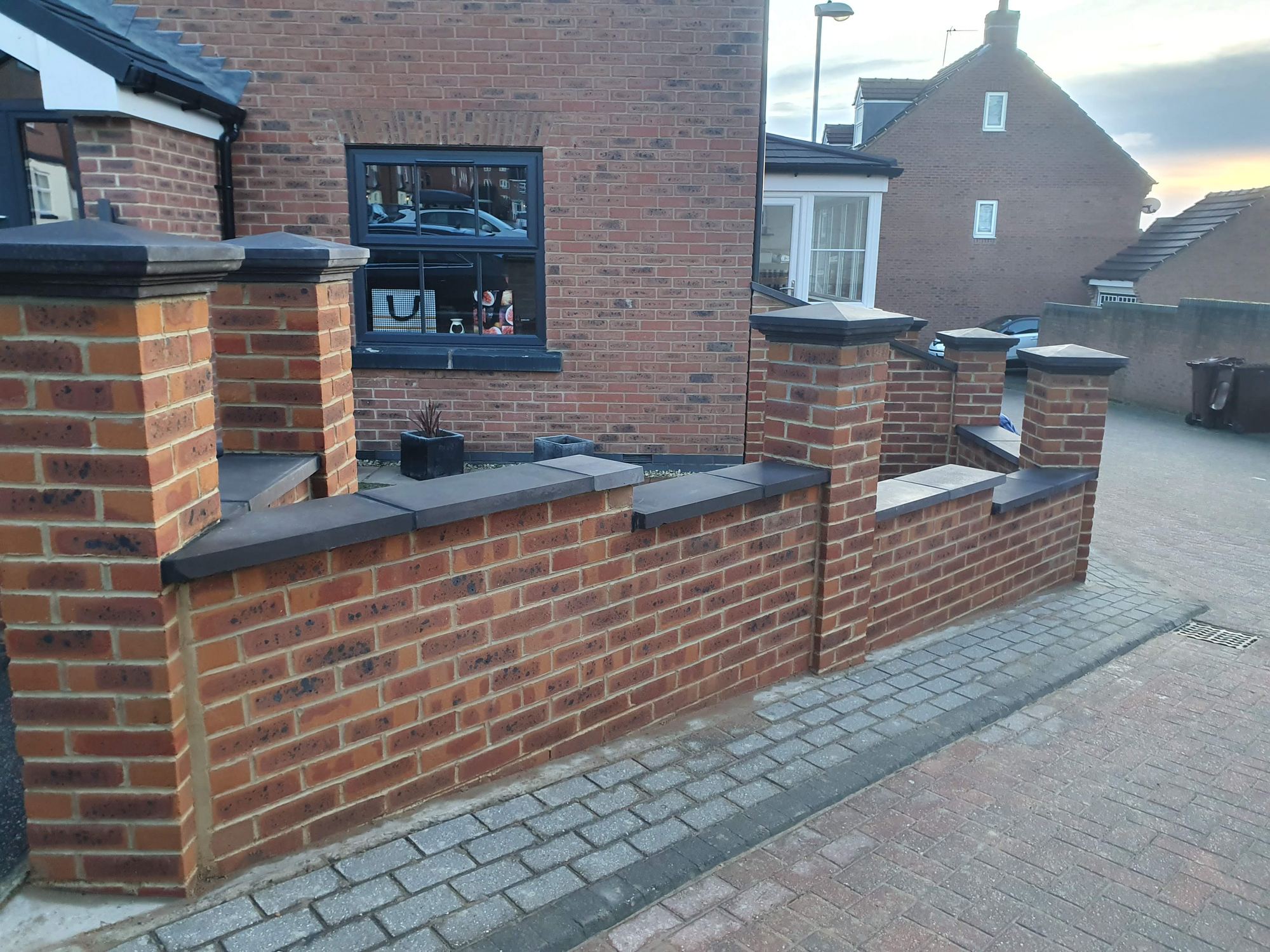 Finished block paving driveway, herringbone laid, house behind