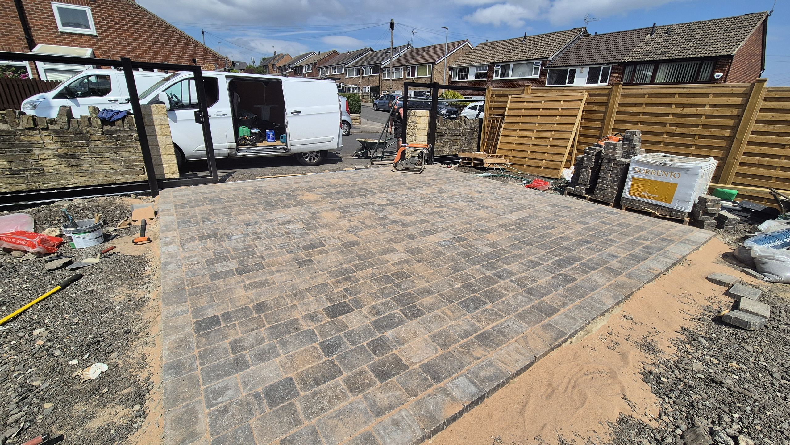 Tumbled block paving driveway under way in full sun in Pudsey, stone wall and new gate posts behind