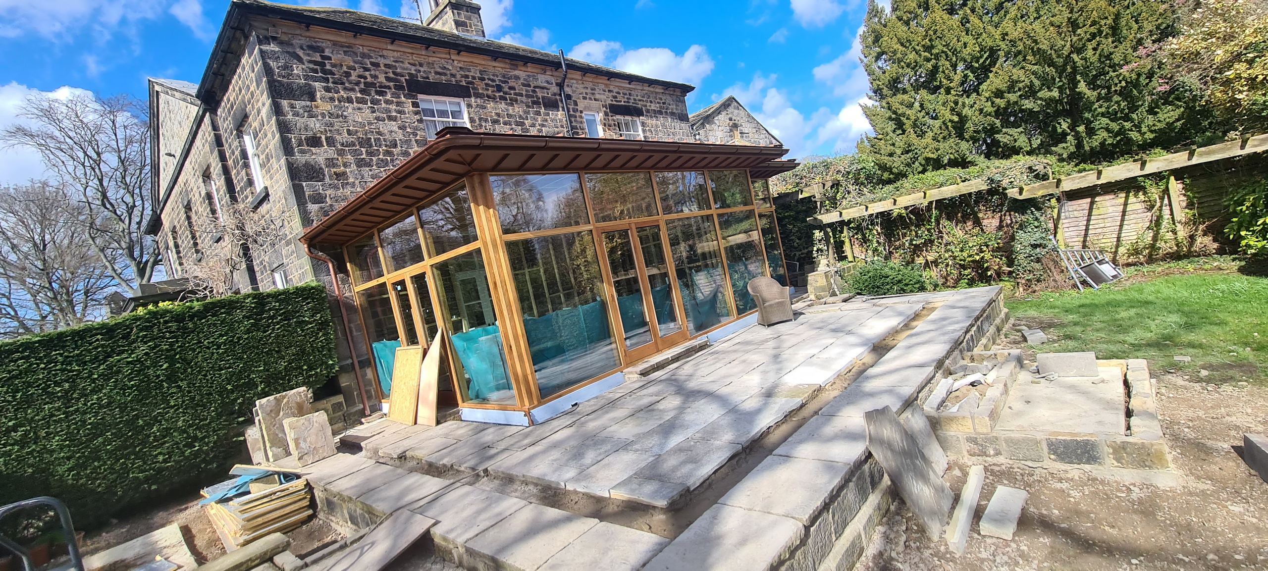Oak garden room extension at a stone house in Adel, new flag patio underway