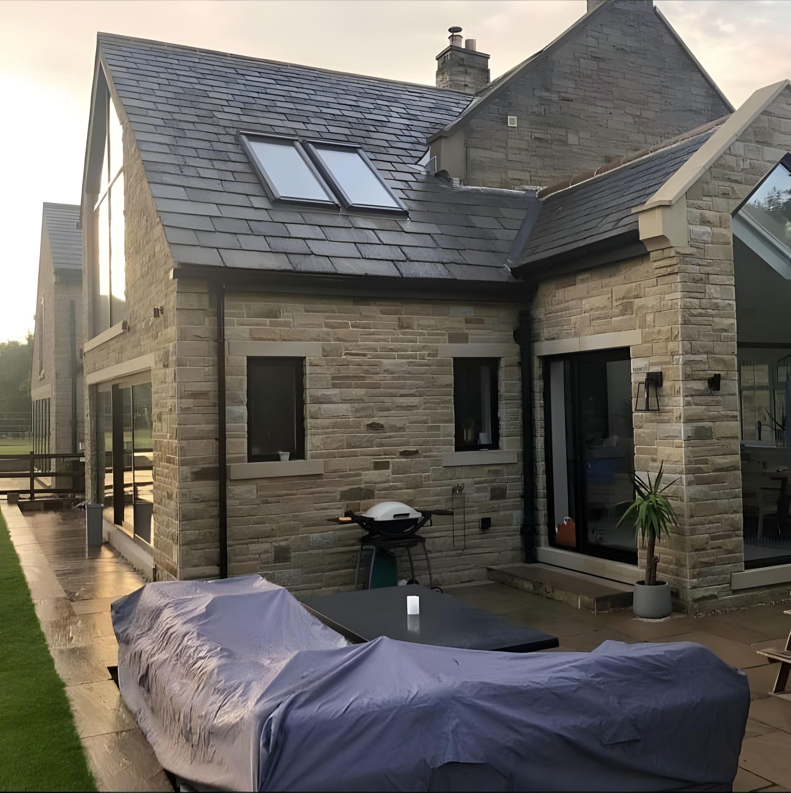 The stone-matched extension, finished, wide from the garden