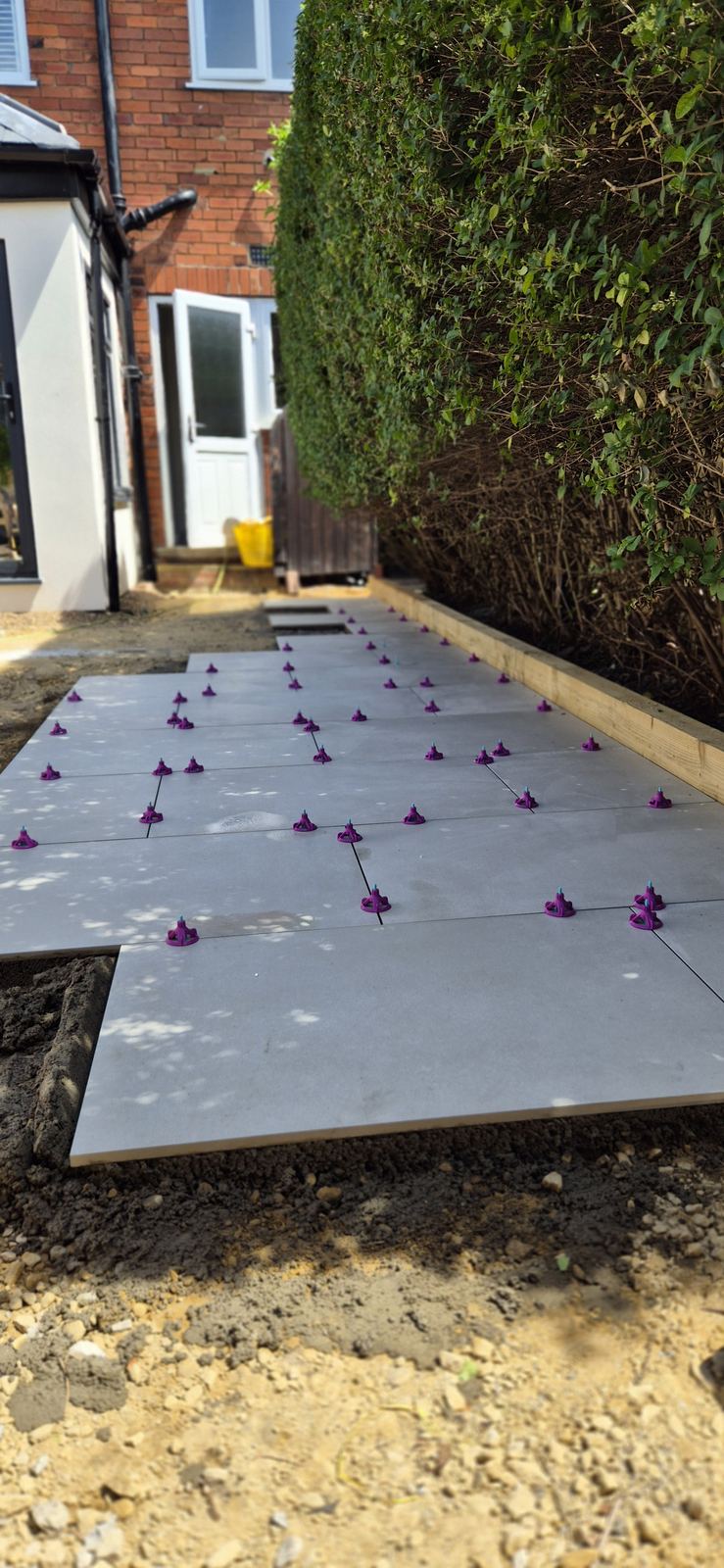 grey porcelain flags going down on levelling spacers