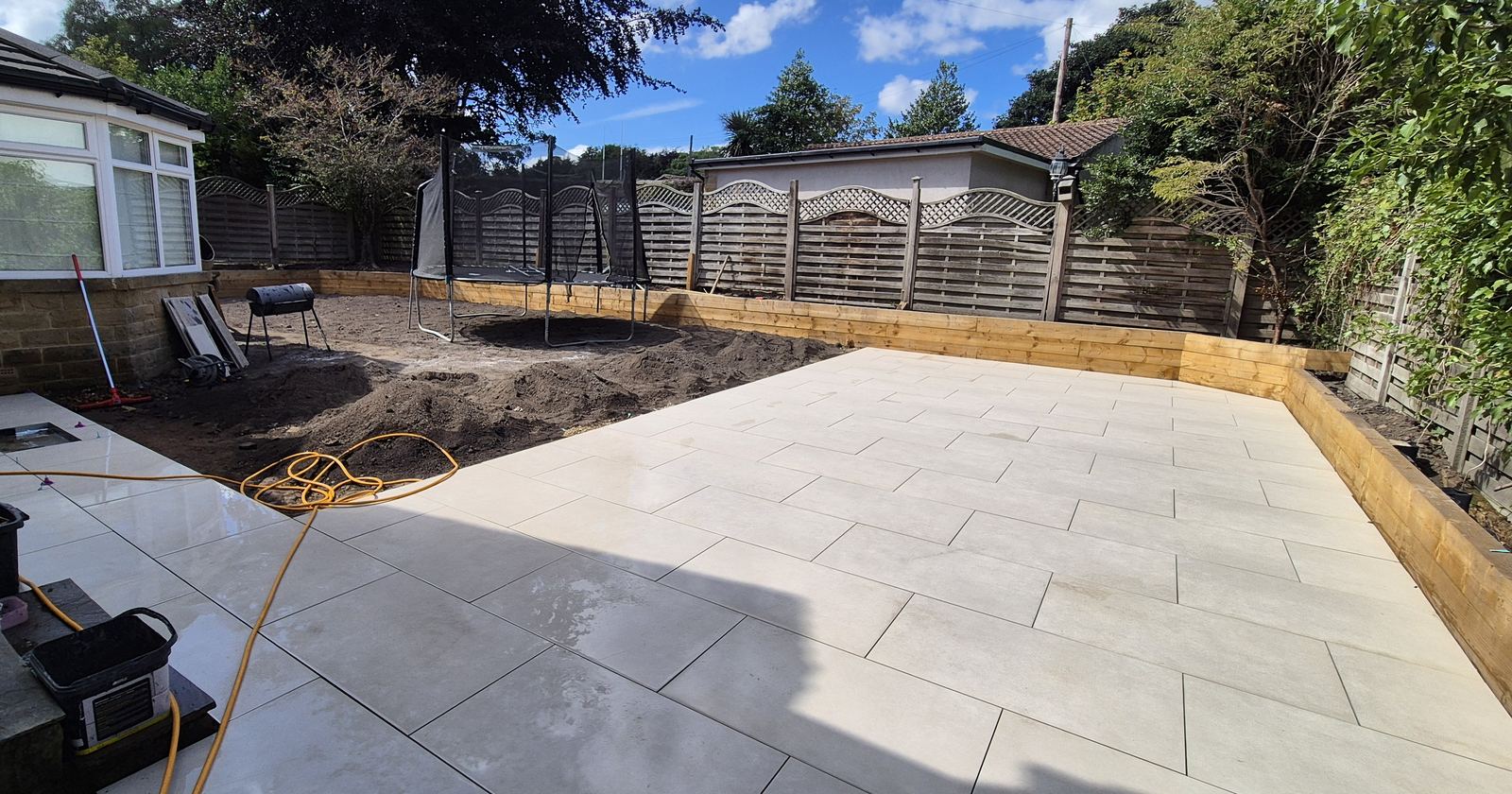 fresh porcelain patio, wide, timber sleeper beds behind
