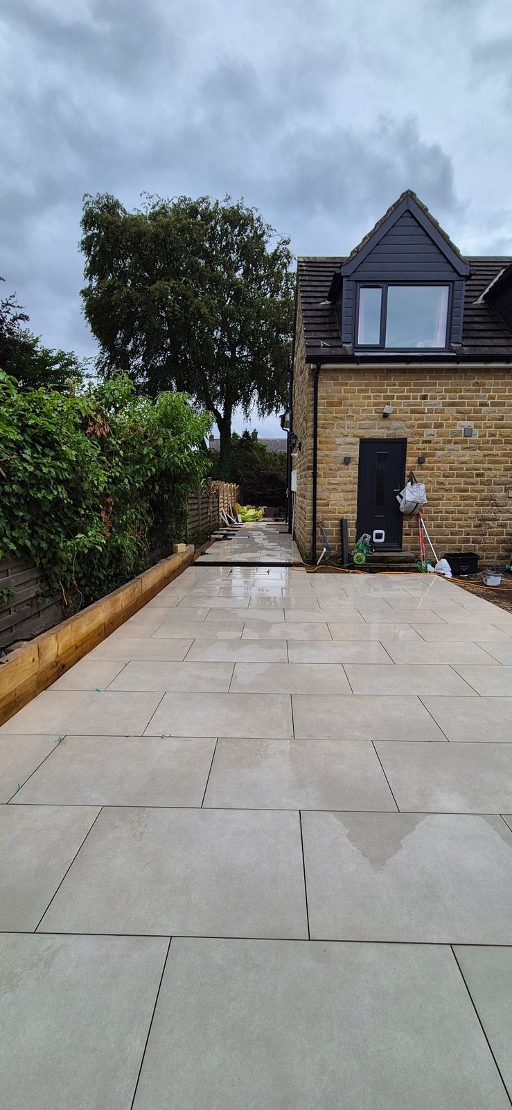 large-format porcelain patio just laid, running to the house
