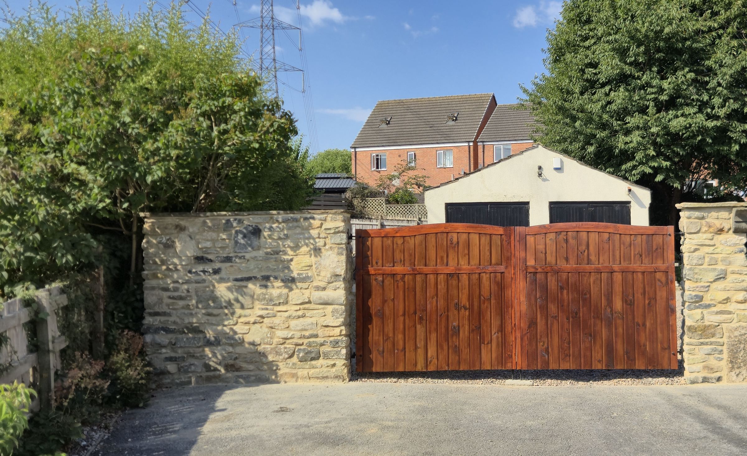 Finished natural stone boundary walls and gate piers with timber gates, at a house in Sitlington, near Wakefield