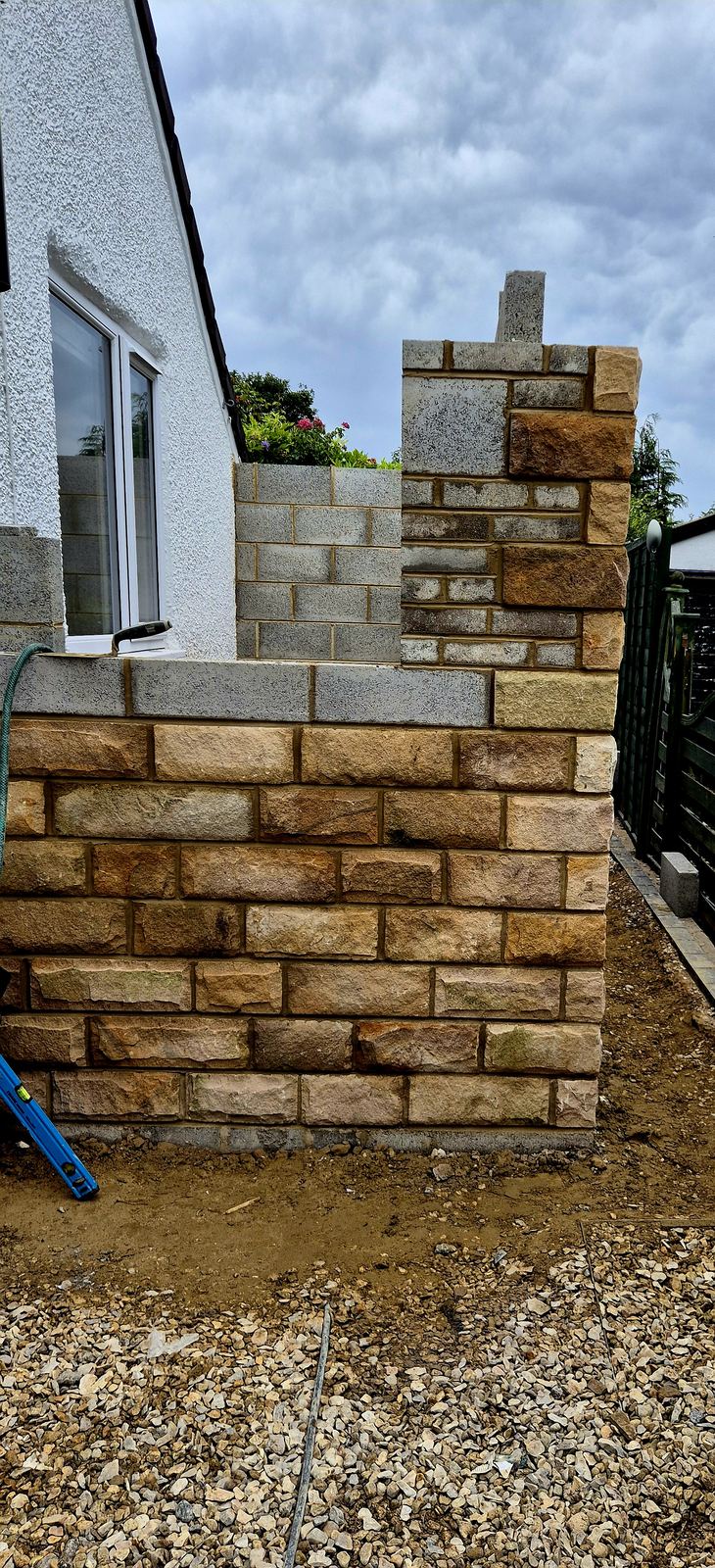 Rebuilt reclaimed stone garden wall with reset coping