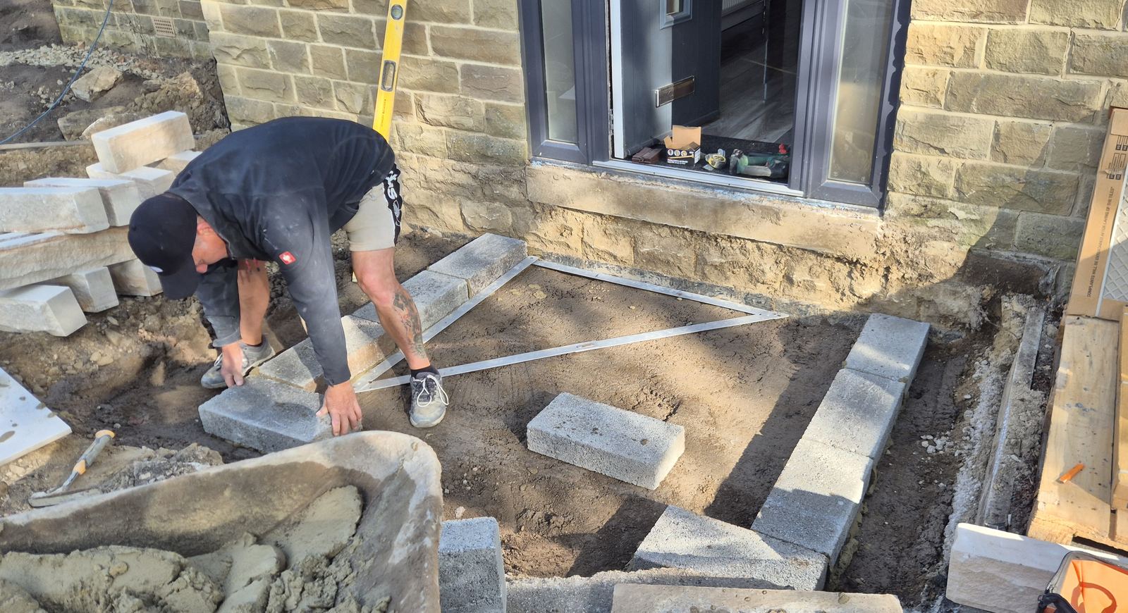 the porch set out on the first morning, tape and level out, first blocks bedded