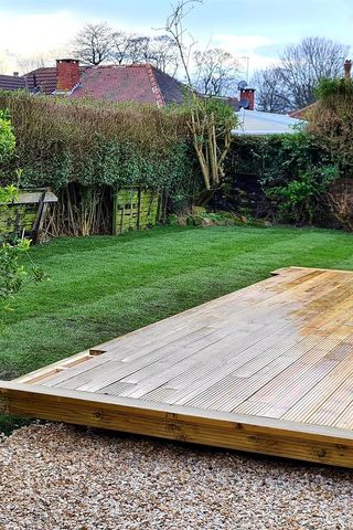 A ground-level timber deck beside a new lawn