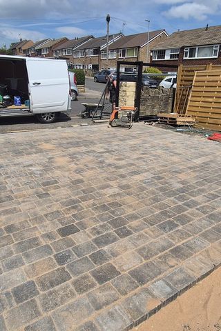 A tumbled block paving driveway being laid