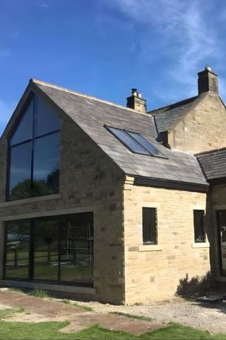 A stone extension with a full-height glazed gable