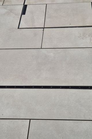 Porcelain slabs laid with tight, even joints around a recessed drainage channel