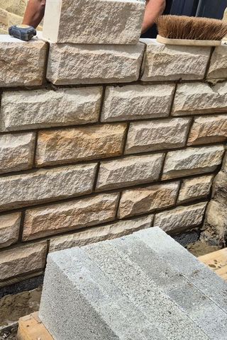 Dressed stone being coursed and pointed on a dwarf wall