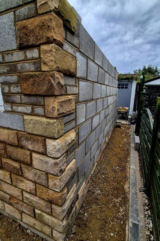 The corner of a stone garden wall with toothed quoins