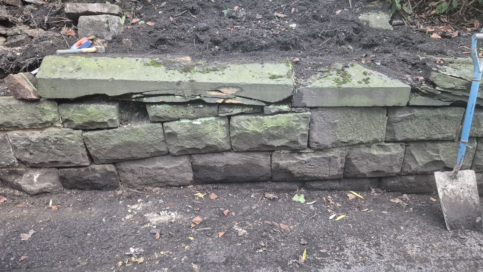 coping stones being reset on an old boundary wall